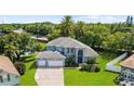 Beautiful two-story home with a three-car garage, lush landscaping, and well-manicured lawn at 13044 Lakeshore Grove Dr, Winter Garden, FL 34787
