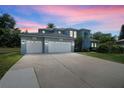 Elegant two-story home boasts a three-car garage and well-manicured lawn, reflecting sophisticated curb appeal at 13044 Lakeshore Grove Dr, Winter Garden, FL 34787