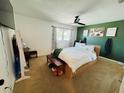 Bright and airy primary bedroom features a green accent wall, ceiling fan and large window with natural light at 1419 Avenue D Ne, Winter Haven, FL 33881