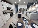 Bright kitchen featuring stainless steel appliances, stone countertops, white cabinets, and island with dark wood accents at 14963 Yorkshire Run Dr, Orlando, FL 32828