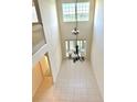 Bright, tall foyer with lots of natural light and a hanging chandelier, tiled floor and transom window at 15851 Woodland Spring Ct, Orlando, FL 32828