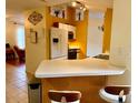 Kitchen area featuring a breakfast bar with seating, white cabinets, and stainless appliances at 1820 Hallcrest Dr, Deltona, FL 32725