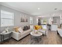 Spacious living room with wood-look tile floors, modern decor, and lots of natural light at 2281 Canyon Breeze Ave, Kissimmee, FL 34746