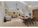 Open-concept living and dining area with vaulted ceilings and neutral tile flooring at 2398 Queenswood Cir, Kissimmee, FL 34743
