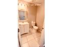 Cozy bathroom featuring a vanity, toilet, tile flooring and decorative lighting at 242 Abbotsbury Dr, Kissimmee, FL 34758