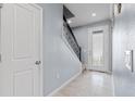 Light and airy entryway with tiled floors, staircase with wrought iron railing, and a glass panel front door at 3084 Slough Creek Dr, Kissimmee, FL 34744