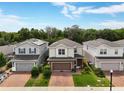 Two-story home with a brick paver driveway and manicured lawn, nestled between two similar properties at 3084 Slough Creek Dr, Kissimmee, FL 34744