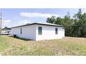 Side view of a well-maintained home with a spacious green backyard at 318 Cocoa Ct, Kissimmee, FL 34758