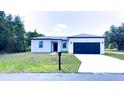 Inviting single-story home showcasing manicured front lawn, convenient mailbox, and a sleek, modern garage door at 318 Cocoa Ct, Kissimmee, FL 34758