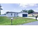 Attractive single-story home boasting a lush front yard, curbside mailbox, and a stylish, contemporary garage door at 318 Cocoa Ct, Kissimmee, FL 34758