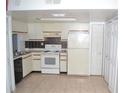 Functional kitchen with tile flooring, white appliances, and ample storage at 3214 Rio Grande Trl # 1, Kissimmee, FL 34741