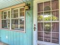 Close-up view of a light blue home with a vintage-style front door and window at 401 Maryland Ave, St Cloud, FL 34769