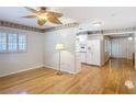 Open-concept living room with hardwood floors, shuttered windows, and adjacent kitchen at 401 Maryland Ave, St Cloud, FL 34769