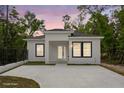 Front elevation of a newly renovated one-story home featuring a white exterior and black-trimmed windows at 610 E Euclid Ave, Deland, FL 32724