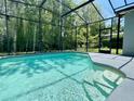 A sparkling in-ground pool and screened-in enclosure with lights create an inviting backyard oasis at 671 Carey Way, Orlando, FL 32825