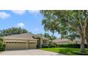 Well-maintained home featuring a three-car garage, lush landscaping, and inviting curb appeal at 714 Regina Cir, Oakland, FL 34787
