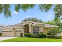 Charming home featuring a three-car garage, manicured lawn, and beautiful landscaping at 714 Regina Cir, Oakland, FL 34787