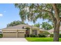 Beautiful home features a three-car garage, manicured lawn, and mature trees for added curb appeal at 714 Regina Cir, Oakland, FL 34787