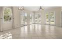Bright and airy living room featuring tile floors, multiple French doors, and abundant natural light at 7505 Mourning Dove Cir # 201, Reunion, FL 34747