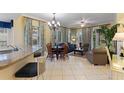 Open-plan living room featuring tile floors, elegant furnishings, and natural light streaming through large windows at 7509 Mourning Dove Cir # 201, Reunion, FL 34747