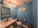 Stylish half bath with blue walls, modern vanity, and elegant fixtures at 101 Grand Junction Blvd, Orlando, FL 32835