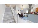 Bright dining area adjacent to the staircase with decorative rug and pendant lighting at 101 Grand Junction Blvd, Orlando, FL 32835