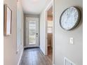 Bright foyer with wood-look tile flooring, a decorative clock, and a door with decorative glass at 1029 Umbria Dr, Poinciana, FL 34759