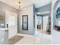 Bright entryway features neutral walls, tiled floors, stylish lighting, and decorative wall art at 112 Grand Canal Dr, Poinciana, FL 34759