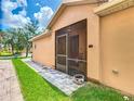 Relaxing screened patio offers an outdoor living space with views of the green backyard at 112 Grand Canal Dr, Poinciana, FL 34759