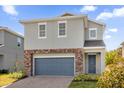 Charming two-story home with a blue garage door, brick accents, and a well-maintained front lawn at 1251 Ash Tree Cv, Casselberry, FL 32707