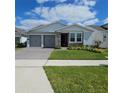 Charming single-story home with a well-manicured lawn, gray garage doors, and a beautiful stone facade at 19235 Allium Pl, Orlando, FL 32827