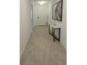 Inviting hallway featuring a white door, light tile flooring, a stylish table, and decorative wall art at 19235 Allium Pl, Orlando, FL 32827