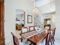 Formal dining room featuring an elegant chandelier, a long wooden table with seating for six, and neutral wall colors at 207 Bailey Cir, Davenport, FL 33897