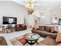 Spacious living room featuring vaulted ceilings, tile flooring, two sofas, and a large flatscreen television at 207 Bailey Cir, Davenport, FL 33897