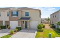 Well-manicured lawn and garden beds enhance the curb appeal of this charming townhome at 2302 Tay Wes Dr, St Cloud, FL 34771