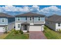Lovely two-story home with a brick driveway, well-kept lawn, and a covered entrance at 2310 Raven Ridge Rd, Minneola, FL 34715
