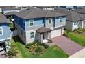 Attractive two-story home with a brick driveway, landscaped front yard, and a two-car garage at 2310 Raven Ridge Rd, Minneola, FL 34715