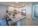 Modern kitchen with granite countertops, stainless steel appliances and eat-in island with seating at 248 Cheshire Ct, Kissimmee, FL 34758