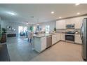 Open kitchen featuring granite countertops, stainless steel appliances and views into the living room at 248 Cheshire Ct, Kissimmee, FL 34758