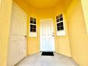 Inviting entryway with a white front door, small windows, and a bright yellow wall for a cheerful welcome at 2788 Sun Key Pl, Kissimmee, FL 34747