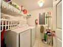 Functional laundry room with a washer, dryer, shelving, and storage options for convenience at 2788 Sun Key Pl, Kissimmee, FL 34747