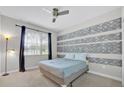 Comfortable bedroom with a ceiling fan and a window that provides natural light and pleasant outdoor views at 2985 Banana Palm Dr, Kissimmee, FL 34747