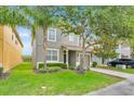 Charming two-story home features a well-manicured lawn, a two-car garage, and mature trees offering ample shade at 2985 Banana Palm Dr, Kissimmee, FL 34747