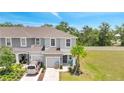 Two-story townhome with a one-car garage, a well-manicured lawn, and mature trees at 3617 Anibal St, Kissimmee, FL 34746