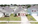 Aerial view of a well-maintained single-Gathering home featuring beautiful landscaping and a two-car garage at 3690 Maidencain St, Clermont, FL 34714