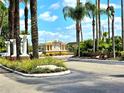 Welcoming community entrance with manicured landscaping, mature palm trees, and a clear sign at 5451 Vineland Rd # 111, Orlando, FL 32811