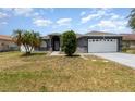 Charming single-story home featuring a manicured lawn and a two-car garage at 604 Kangaroo Dr, Poinciana, FL 34759