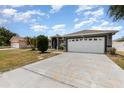 Well-maintained single-story home with an attached two-car garage and long driveway at 604 Kangaroo Dr, Poinciana, FL 34759