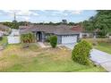 Charming single-story home featuring a manicured lawn and a two-car garage at 604 Kangaroo Dr, Poinciana, FL 34759