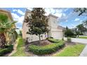 View of the side and front of this charming home with neat landscaping and a red tile roof at 6041 Broad Oak Dr, Davenport, FL 33837